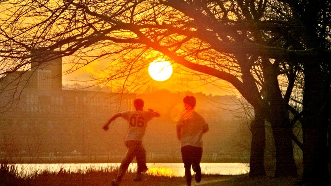 Cambridge, MA - 2/3/06 A jogger runs along the Charles River in Cambridge at sunset Friday. 020306featuredg - Staff Photo by David Goldman. Saved in Photo SATURDAY.