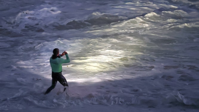 Laguna Beach, CA - June 9, 2026: Laguna Beach lifeguards search the beach below the Montage Resort where a girl was swept off the rocks by big waves on Tuesday in Laguna Beach, CA on June 9, 2026.