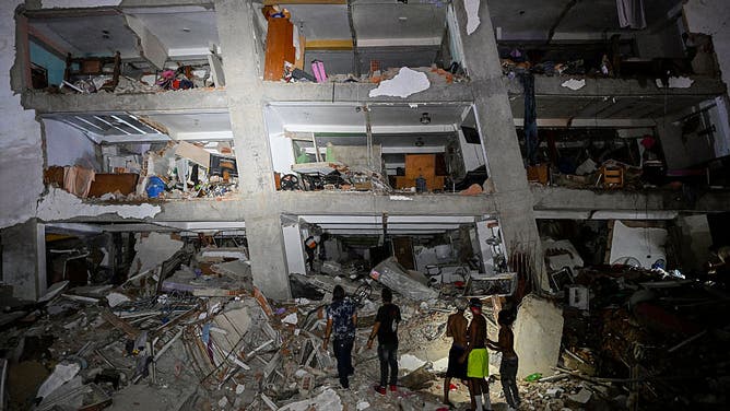 People stand in the rubble near a damaged building following an earthquake in Catia La Mar, La Guaira State, some 30kms north-west of Caracas, early on June 25, 2026.