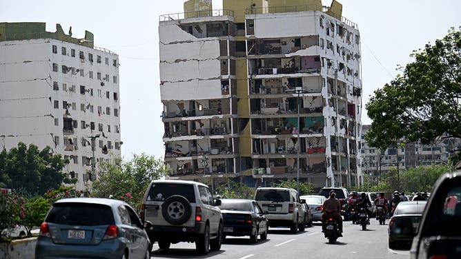 Traffic moves along a road past heavily damaged apartment buildings following an earthquake in Catia La Mar, La Guaira state, about 30 km northwest of Caracas, on June 25, 2026.
