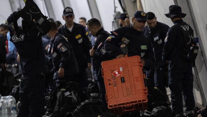 Members of Colombian Urban Search and Rescue (USAR) carry equipment while getting ready to depart with humanitarian aid to Venezuela at Catam Air Base in Bogota on June 26, 2026, following deadly earthquakes.