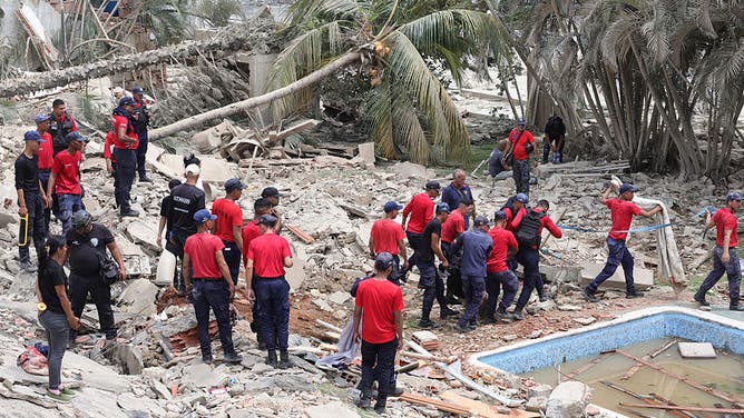 C.P.N.B workers and police members tend a victim amid debris of demolished buildings as rescue efforts continue after a magnitude 7.2 earthquake struck Venezuela and other regions in the Caribbean on June 25, 2026 in La Guaira, Venezuela. 