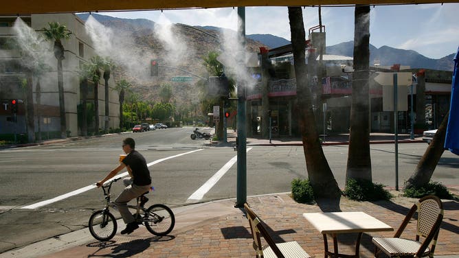 PALM SPRINGS, CA - JULY 5: A cyclist cools his ride by passing through misters near the unoccupied tables of a sidewalk caf? as the official temperatures hovers around 112 degrees Fahrenheit in the shade, according to the National Weather Service, July 5, 2007 in Palm Springs, California. Shade temperatures in some nearby areas hovered around 116 degrees. The first major heat wave of the summer is gripping the Southwest this week as parts of southern California experience the driest year on record.