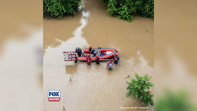Members of the Tahlequah Fire Department in heavy floodwaters.