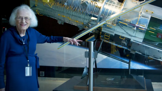 Nancy Grace Roman stands next to a scale model of the Hubble Space Telescope outside the Hubble control center at Goddard Space Flight Center in Greenbelt, MD. Roman is known as the 