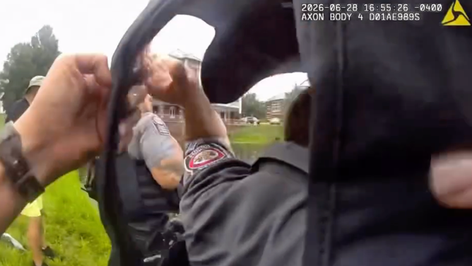 Officers take off their heavy vests before entering the water