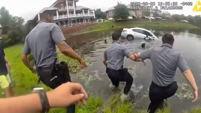 Officers take off their heavy vests before entering the water
