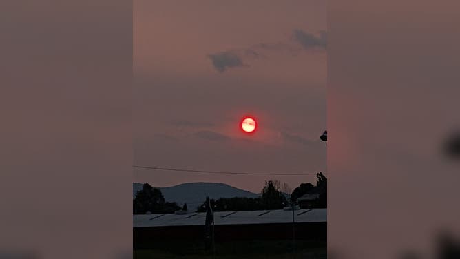 Bright red sun surrounded by hazy skies in Vermont, on Tuesday night