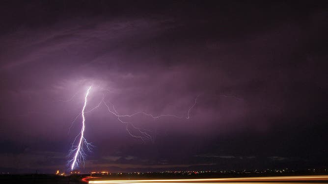 [UNVERIFIED CONTENT] A car zips by as a bolt of lightning rains down from a thunderstorm near Pueblo West Colorado on June 20th 2013.