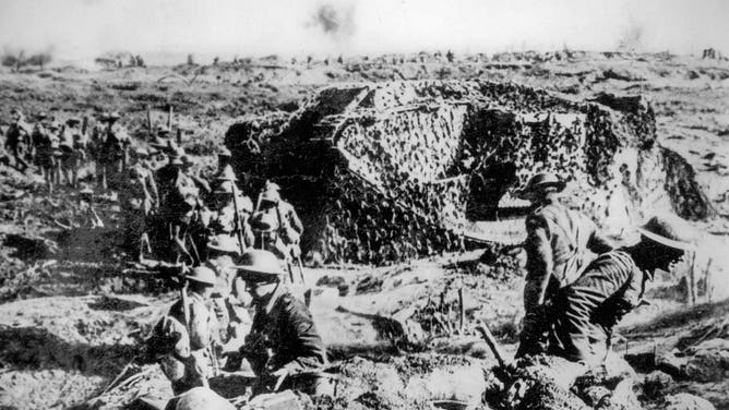 WWI British infantry soldiers and camouflaged tanks during the World War One Battle of Polygon Wood near Ypres. Ieper, West Flanders, Belgium in 1917.
