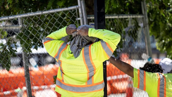 WASHINGTON,DC - JUNE 30: A construction worker wraps a towel around their head for sun protection near DuPont Circle on June 30, 2026, in Washington, DC.