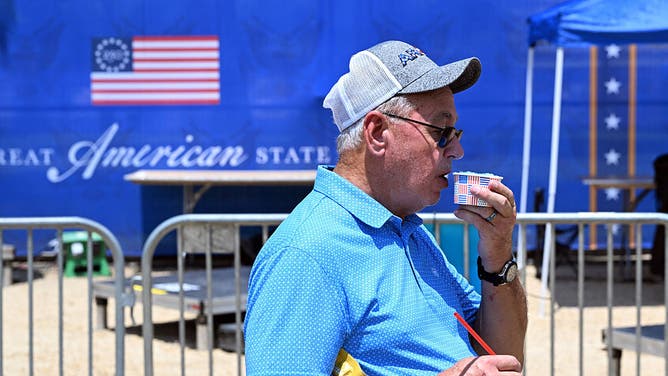 A man enjoys a semi-frozen beverage while visiting "The Great American State Fair" during a heatwave in Washington, DC, on July 1, 2026.