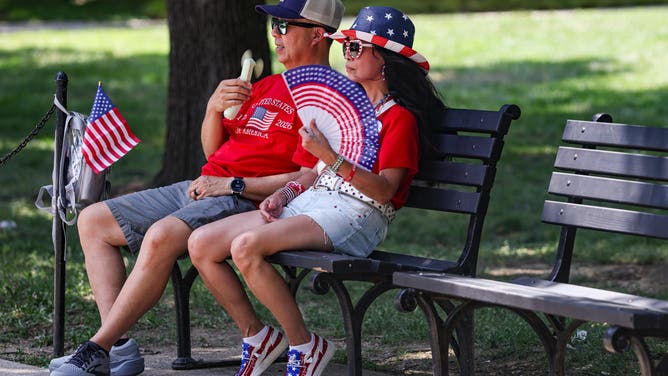 Tourists cool off in the shade during high temperatures in Washington, DC, US, on Friday, July 3, 2026.