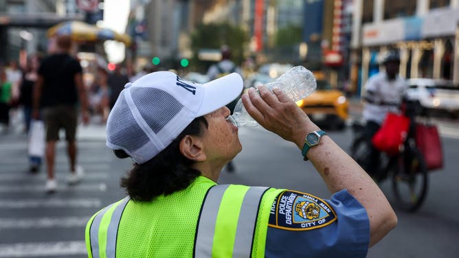 A New York Police Department (NYPD) traffic officer drinks water during high temperatures in New York, US, on Friday, July 3, 2026. A searing heat dome will push electricity demand across the eastern US toward record levels over the July 4 holiday, testing power grids as air conditioners run full tilt on a busy World Cup weekend.
