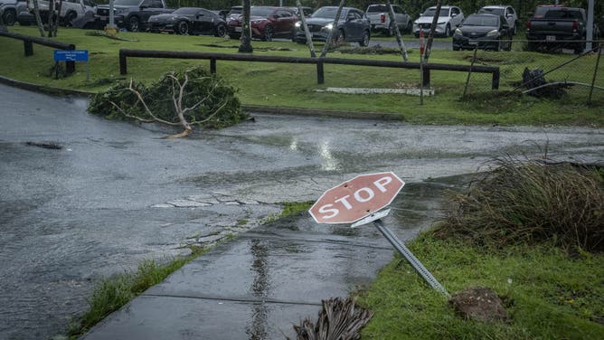 A traffic sign and broken tree lie on the ground after strong winds brought by Super Typhoon Bavi in Guam on July 6, 2026.