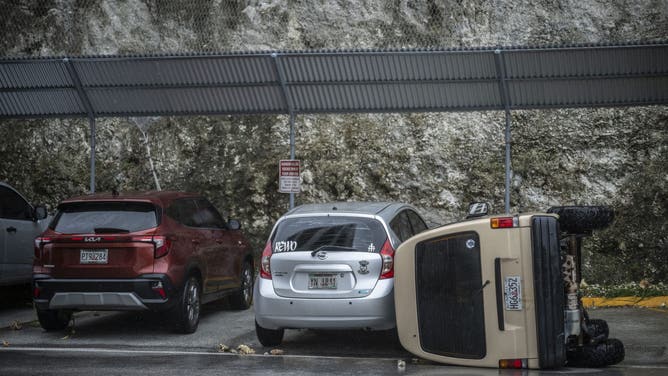 A car lies overturned after being flipped by strong winds brought by Super Typhoon Bavi in Guam on July 6, 2026.