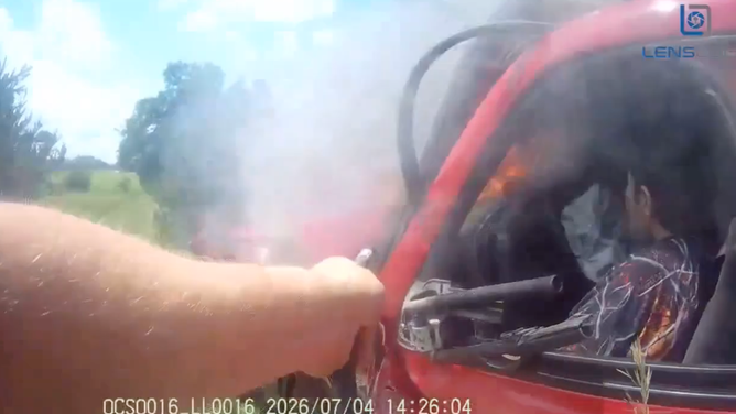 The deputy sprayed the fire extinguisher on the flames.