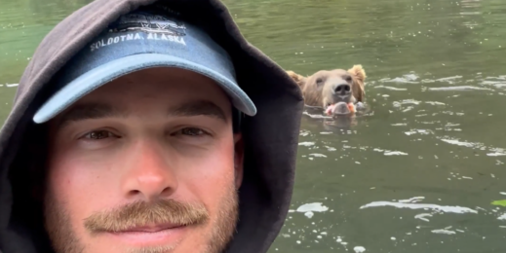 Video: Fisherman and grizzly bear share Alaskan river while hunting for salmon