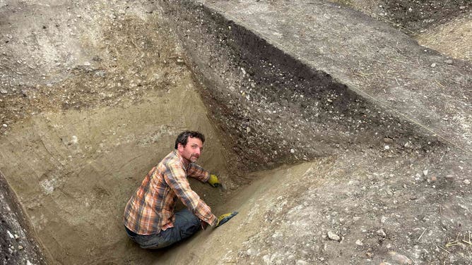 Ditch where archeologists found remains of humans and bull skulls.
