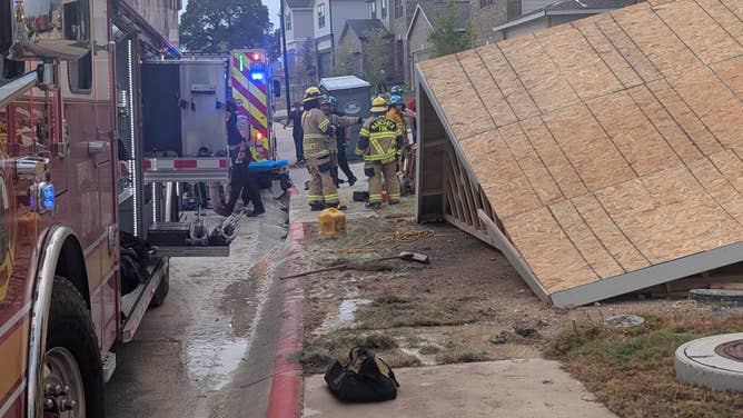 First responders stand in front of the collapsed house.