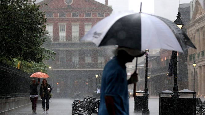 NEW ORLEANS, LA - OCTOBER 07: Tourists run to avoid the rain as strong winds and heavy rain from Hurricane Nate begin to come ashore on October 7, 2017 in New Orleans, Louisiana.