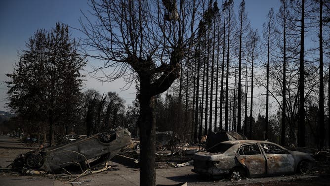SANTA ROSA, CA - OCTOBER 12: An overturned car sits in front of homes that were destroyed by the Tubbs Fire on October 12, 2017 in Santa Rosa, California. Twenty four people have died in wildfires that have burned tens of thousands of acres and destroyed over 3,500 homes and businesses in several Northern California counties.