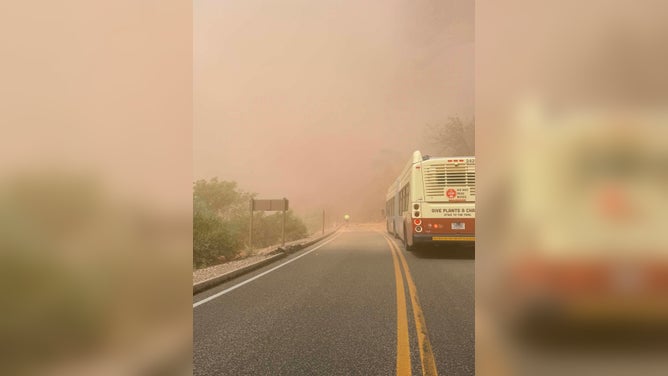 A bus sits at the edge of a rock collapse in Zion National Park.