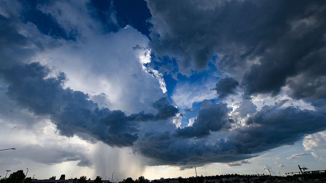 FILE - Heavy rain and dark, heavy clouds cover homes in the Kissimmee area of Florida on Thursday afternoon, August 31.