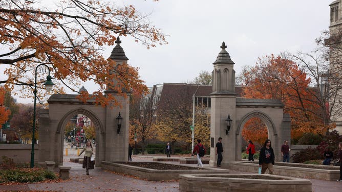 BLOOMINGTON, INDIANA – NOVEMBER 07: Students pass through the Sample Gates as autumn leaves hang over Kirkwood Avenue on the Indiana University campus on November 7, 2025 in Bloomington, Indiana.