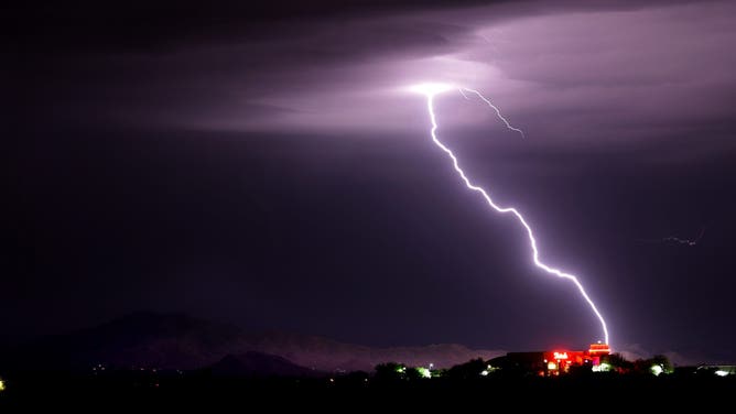 A big bolt of lighting hits in the Santa Rita foothills behind Hotrods Old Vail restaurant, one of hundreds of strikes from of a widespread monsoon storm that rolled over Tucson, Ariz., August 5, 2026.