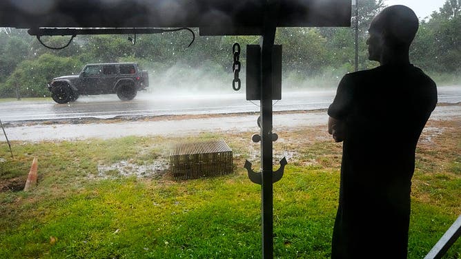 Michael Espinoza stands under the awning of his shop, T&M Bait Shop, watching rain from Tropical Storm Edouard come down in High Island, Tuesday, Sept. 1, 2026.