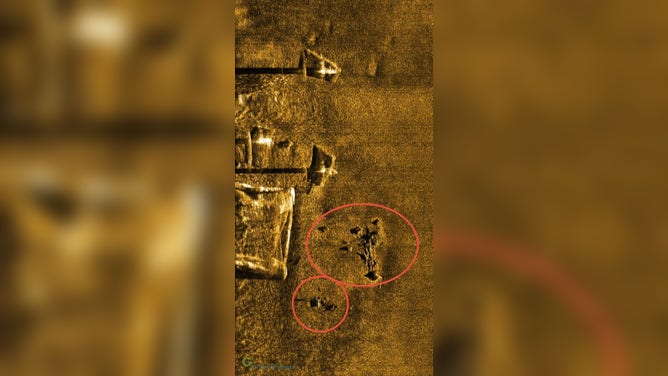 A July 27, 2026 sidescan sonar image captured a detailed image of wreckage within 50
linear feet of the base of one of the Block Island Wind turbines (the square). The long black
shadows are from the jackup barge on location during the survey. The sonar image is a relative
linear feet of the base of one of the Block Island Wind turbines (the square). The long black shadows are from the jackup barge on location during the survey. The sonar image is a relative top-down view, which uses soundwave reflections to create imagery through the water.
