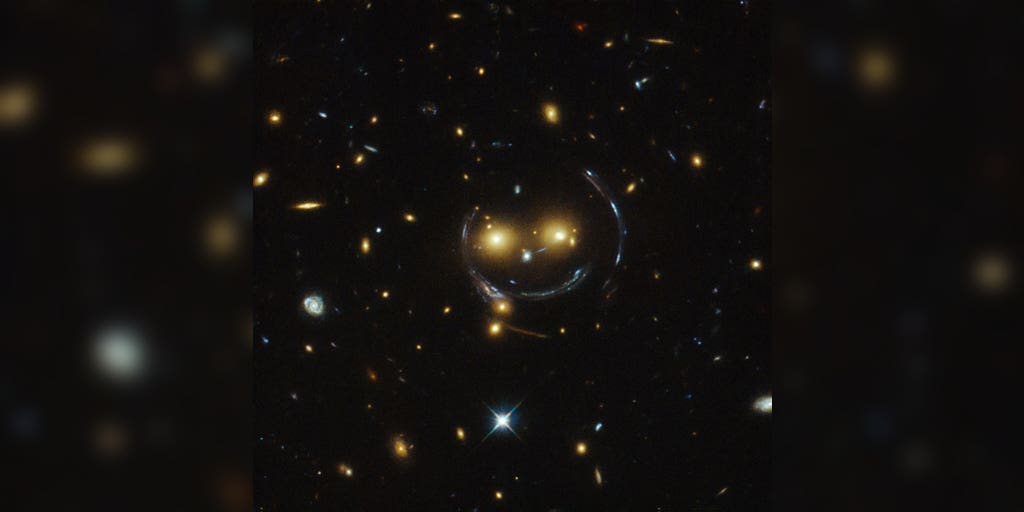 A giant smiley face in space? Hubble captures remarkable galaxy cluster - FOX Weather image