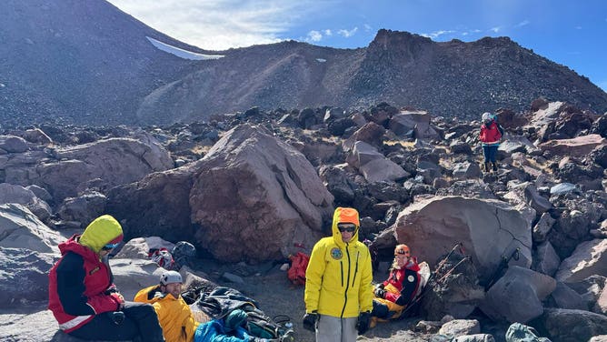 The rescuers take a break while climbing the mountain after several hours.