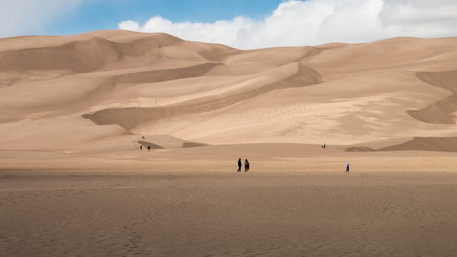 Landscape view of visitors at the dunes in Great Sand Dunes National Park.