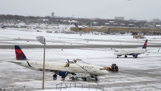 BLOOMINGTON, MN - NOVEMBER 27: A crew works to de-ice a plane at Minneapolis-St. Paul International Airport after a blizzard struck overnight on November 27, 2019 in Bloomington, Minnesota. Snowfalls neared 12 inches in parts of the state on one of the busiest travel days of the year.