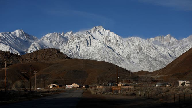 LONE PINE, CA - MARCH 22: Lone Pine Peak, center, elevation 12,949 feet, and Mount Whitney, far right, the highest mountain in the contiguous United States and the Sierra Nevada, with an elevation of 14,505 feet, are located on the east side of the Sierra Nevada mountain range, shown from Whitney Portal Road, on Wednesday, March 22, 2023 in Lone Pine, CA.