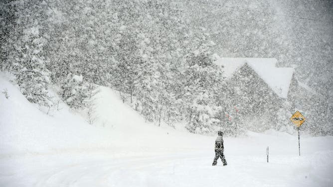 NEDERLAND, COLORADO - MARCH 14: A lone person walks along Highway 119 as heavy amounts of snow falls on March 14, 2021 in Nederland, Colorado.