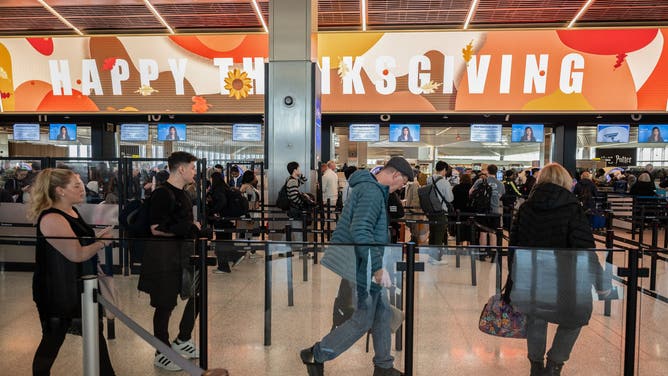 Travelers wait at a Transportation Security Administration (TSA) checkpoint at Newark Liberty International Airport (EWR) in Newark, New Jersey, US, on Monday, Nov. 24, 2025.