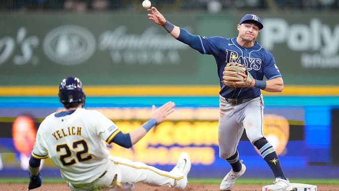 MILWAUKEE, WISCONSIN - APRIL 01: Ben Williamson #15 of the Tampa Bay Rays turns a double play as Christian Yelich #22 of the Milwaukee Brewers slides into second base in the sixth inning at American Family Field on April 01, 2026 in Milwaukee, Wisconsin. 