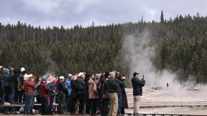 YELLOWSTONE NATIONAL PARK, WYOMING - MAY 21: Visitors wait for Old Faithful Geyser to erupt on May 21, 2026 in Yellowstone National Park, Wyoming.