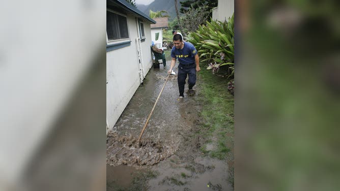 KA'A'AWA, HI - MARCH 3: A fire fighter squeegies water away from a flooded home on March 3, 2006 in the town of Ka'aa'wa on the Windward side of Oahu, Hawaii. Fire fighers and police from all over Oahu worked overtime to help residents on the WIndward side clean up after the flooding in the area. Days of heavy rains on Oahu have flooded roads, caused several landslides and closed schools. Many homes in the area have suffered minor flooding. Fire fighers and police from all over Oahu worked overtime to help residents on the WIndward side clean up after the flooding in the area. More rain is expected next week. The Hawaiian Governor has declared a state of emergency. The Hawaii National Guard is on alert to evacuate people who are in areas prone to flooding.