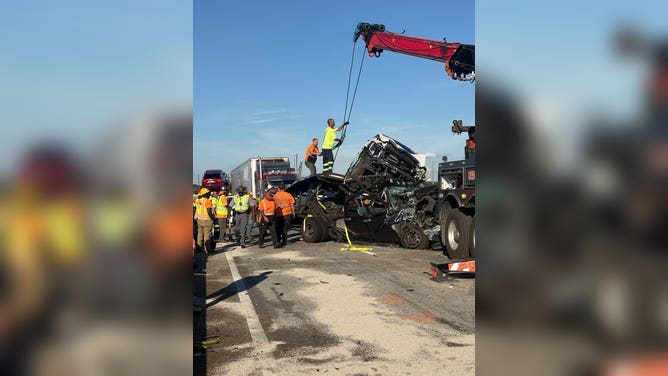 Crews work to clear mangled vehicles after a large pileup along a highway in South Carolina.