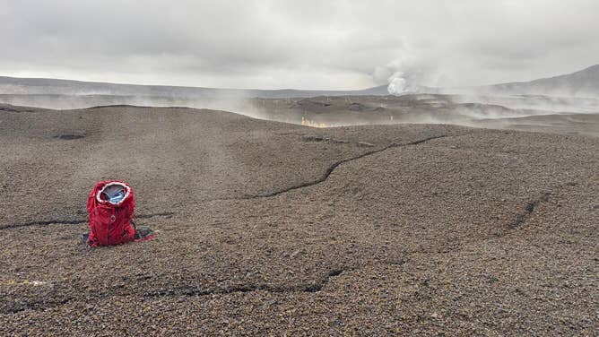 Another view of the new ground cracks in the north part of Kaluapele, Kīlauea summit caldera, cutting through the recent tephra deposits on the caldera floor. New cracks were up to about 6 inches (15 cm) wide. The active vents of the ongoing eruption are visible in the upper right portion of the photo. USGS photo by M. Patrick.