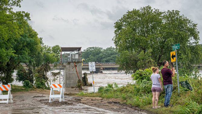 CENTER POINT, TEXAS - JULY 16: People overlook the Guadalupe River after flash flooding occurred along its banks on July 16, 2026 in Center Point, Texas. Flash floods swept across parts of Central Texas, bringing heavy rainfall, prompting evacuations, and triggering multiple water rescues.