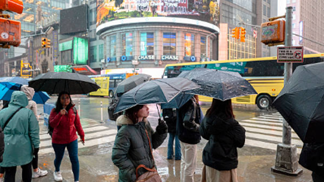 NEW YORK, NEW YORK - MARCH 05: People walk through Time Square during rainfall in New York City on March 05, 2026 in New York, New York.